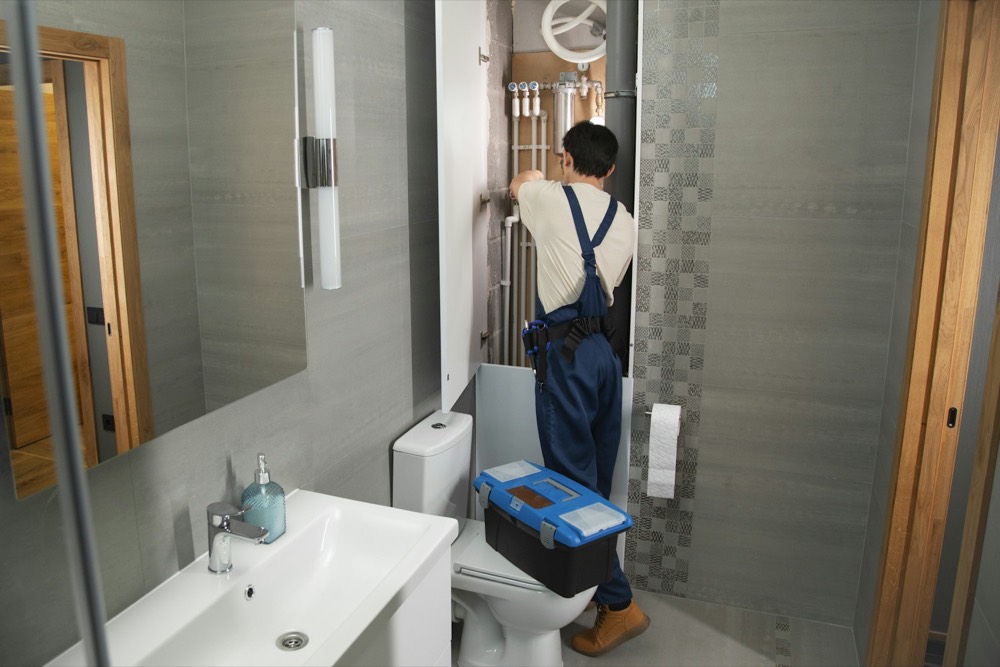 A plumber working in a bathroom