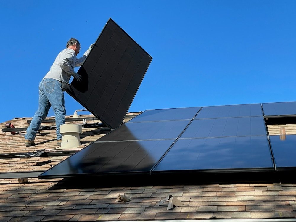 A solar panel being fitted on a roof